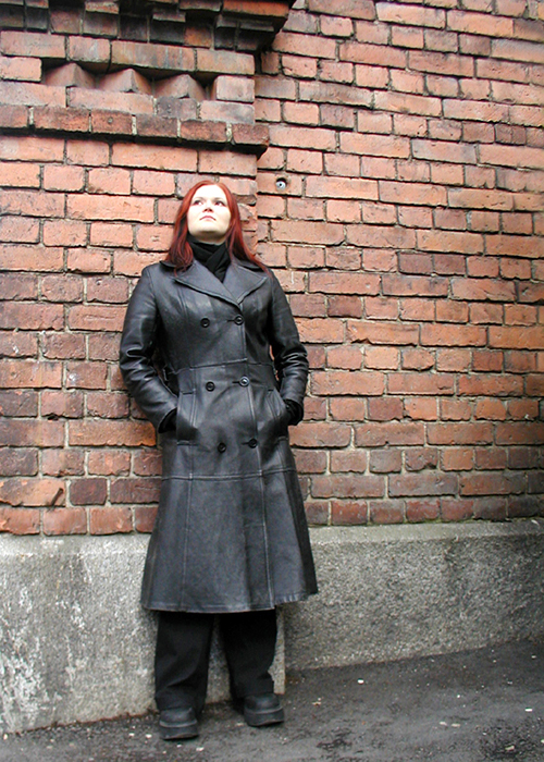 a woman standing in front of a brick wall