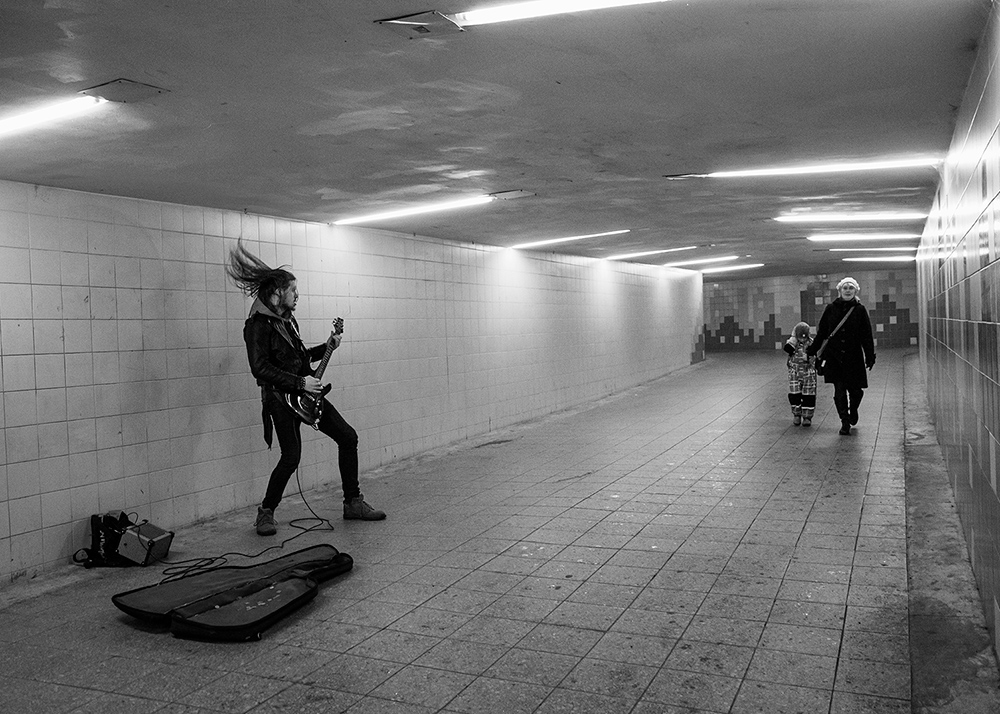 a street musician playing guitar solo too loud a small child