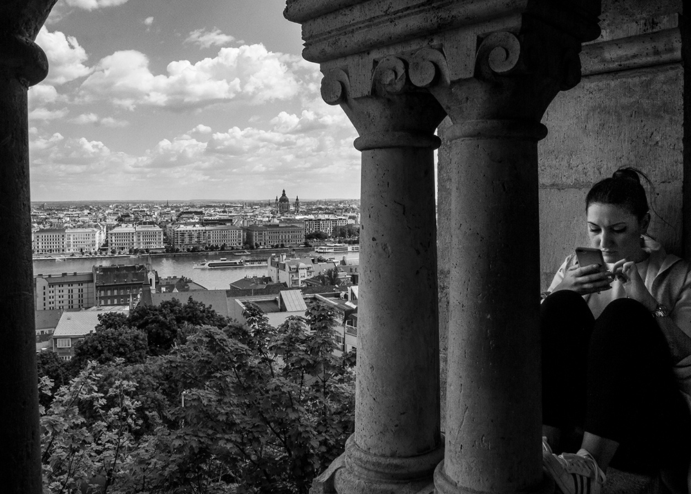 a woman looking at her mobile phone with cityscape on the background