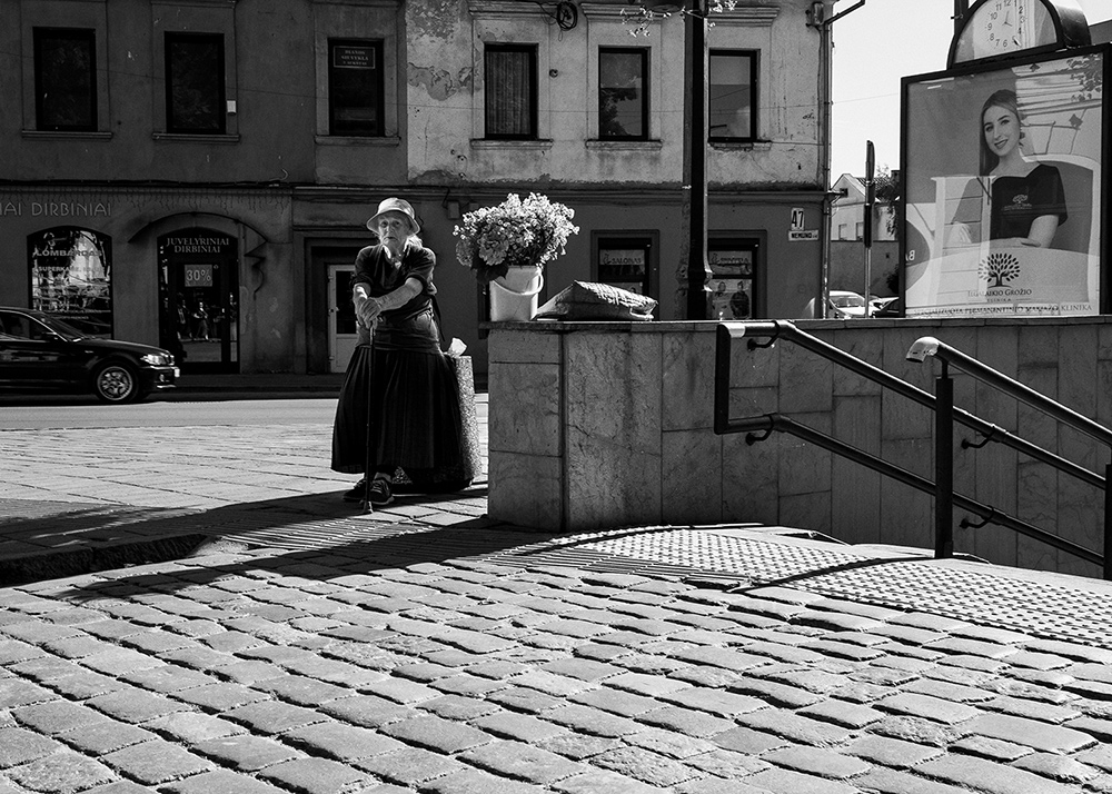 a woman selling flowers on a street